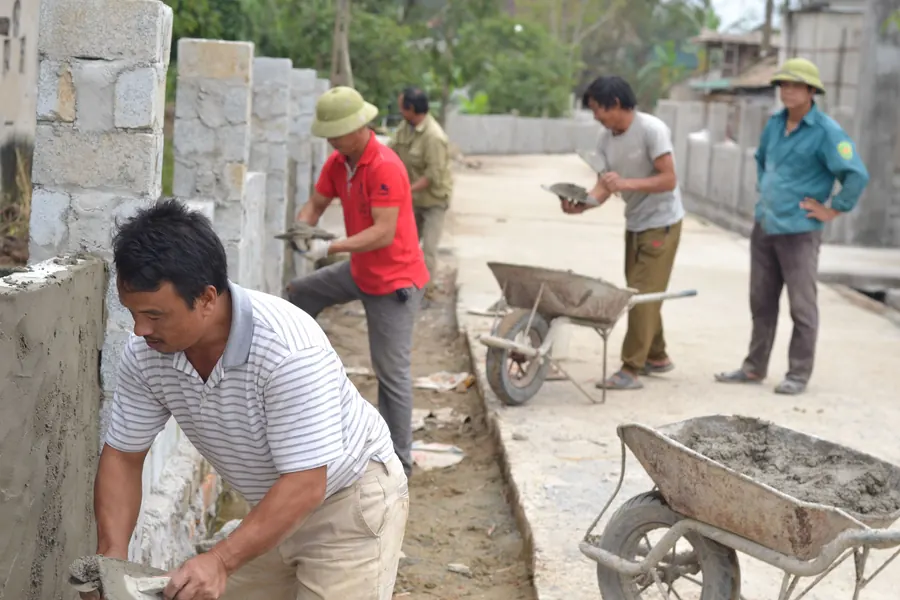 Construction team applying cement while building an external masonry wall