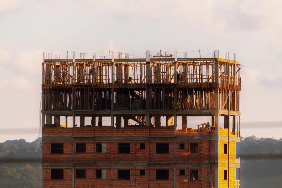 Multi-storey brick building under construction in warm evening light